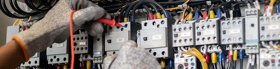 Worker checking readings on electrical panel